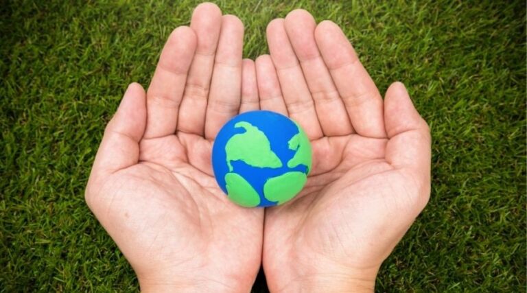hands holding a small ball that looks like the earth